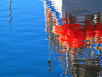 Red Boat Reflection on Blue Water Surface