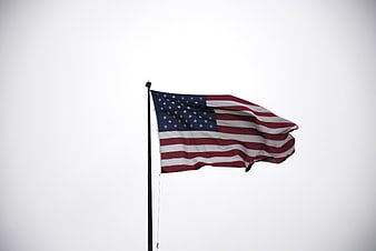 American Flag Waving Against White Sky Background