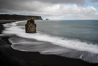Long Exposure Black Sand Beach with Sea Stack and Cliffs