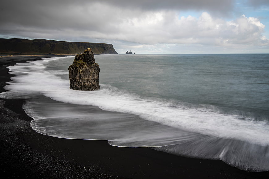 Long Exposure Black Sand Beach with Sea Stack and Cliffs