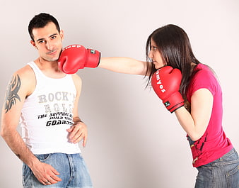 Woman Punching Man in Face with Boxing Gloves