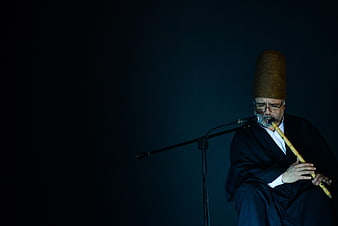 Sufi Dervish Playing Ney Flute in Dark Studio Setting