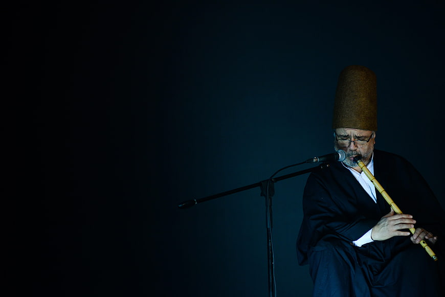 Sufi Dervish Playing Ney Flute in Dark Studio Setting