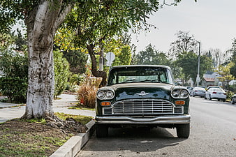 Front view of vintage green classic car parked on street