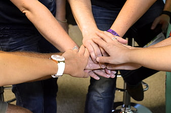 Close-up of diverse hands stacked together in unity