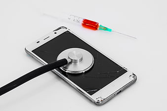 Broken Smartphone with Stethoscope and Syringe on White Background