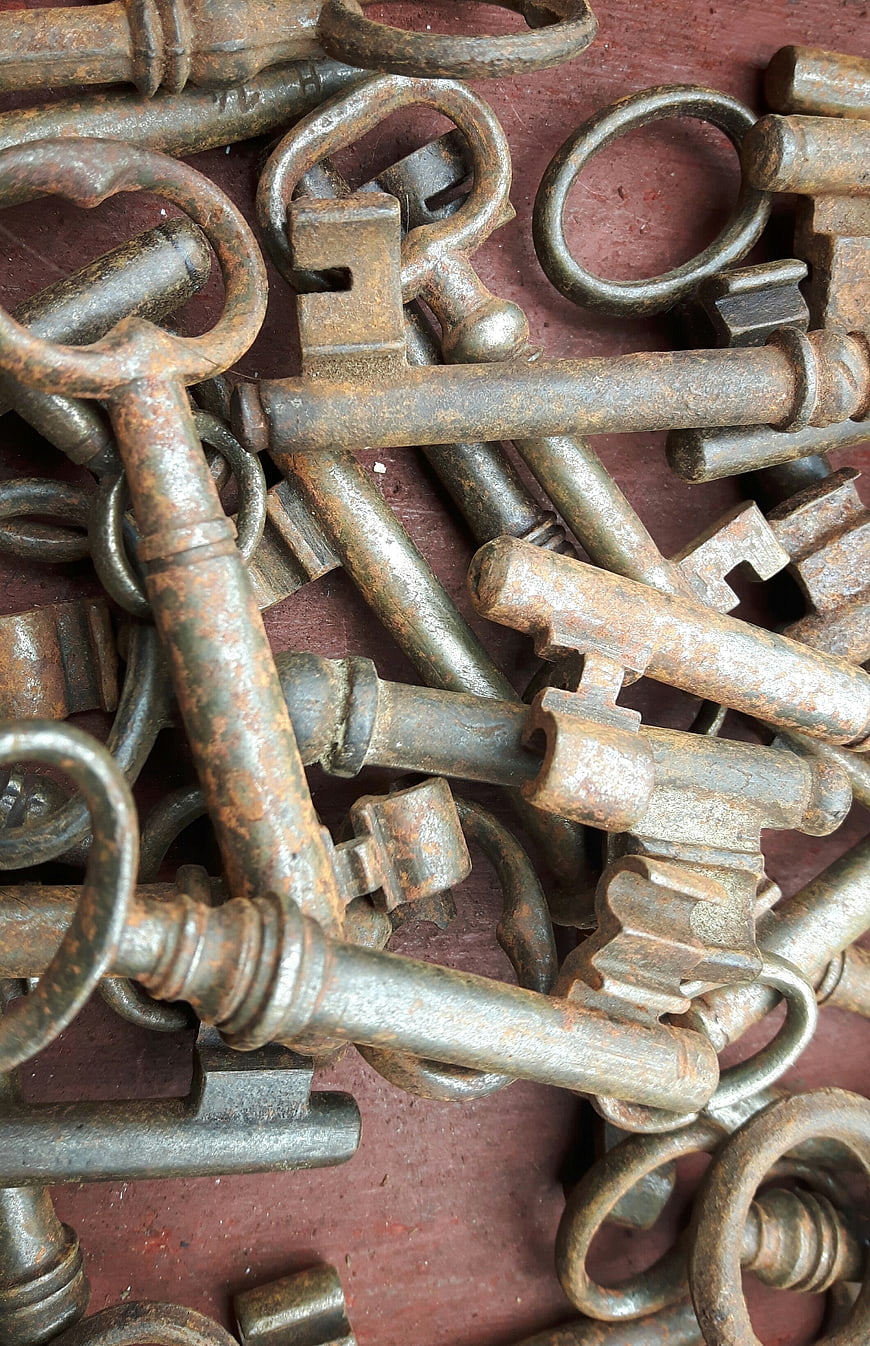 Close-up of vintage rusty skeleton keys on red background
