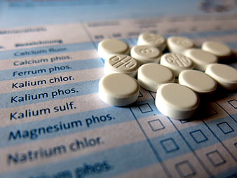 White homeopathic tablets on a medical prescription form