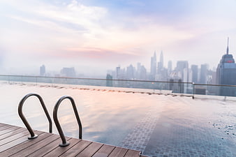 Rooftop Infinity Pool With City Skyline At Sunset