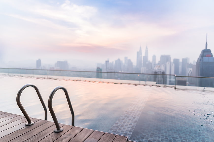 Rooftop Infinity Pool With City Skyline At Sunset