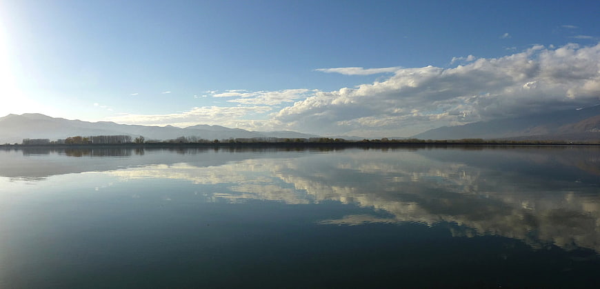 Panoramic Lake Landscape with Cloud Reflections and Mountains