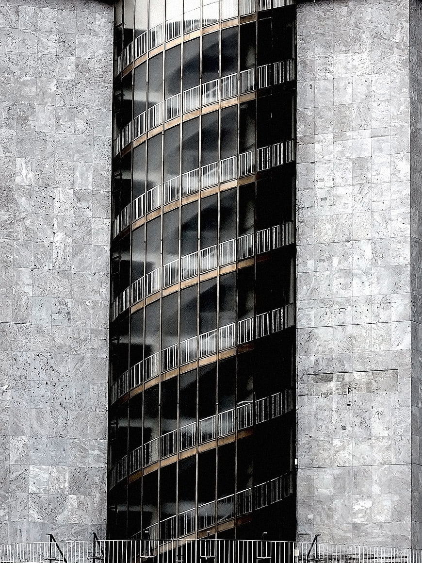 Modern curved glass building facade with concrete walls