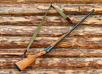 Vintage Wooden Single Shot Hunting Rifle On Log Cabin Wall