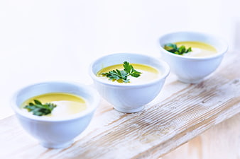 Three bowls of creamy leek soup with parsley garnish