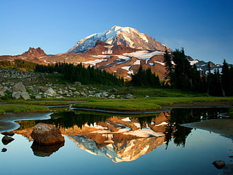 Majestic snow-capped mountain reflected in calm alpine lake