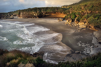 Scenic coastal landscape with sandy beach and golden cliffs