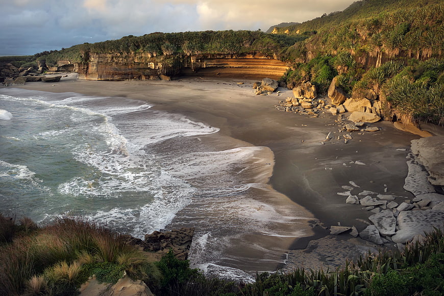 Scenic coastal landscape with sandy beach and golden cliffs
