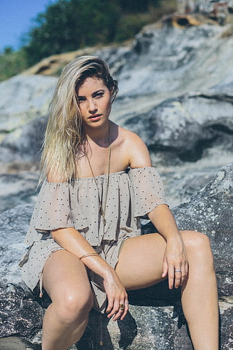 Blonde Woman in Polka Dot Dress Sitting on Rocks