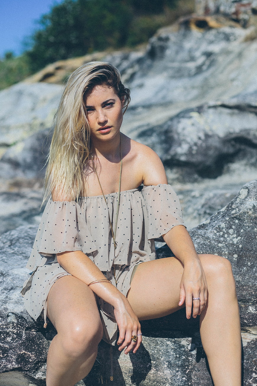 Blonde Woman in Polka Dot Dress Sitting on Rocks
