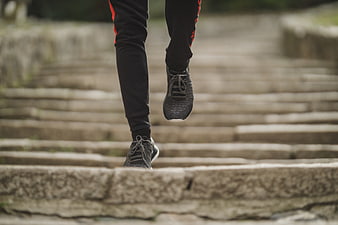 Runner's legs and feet ascending stone stairs