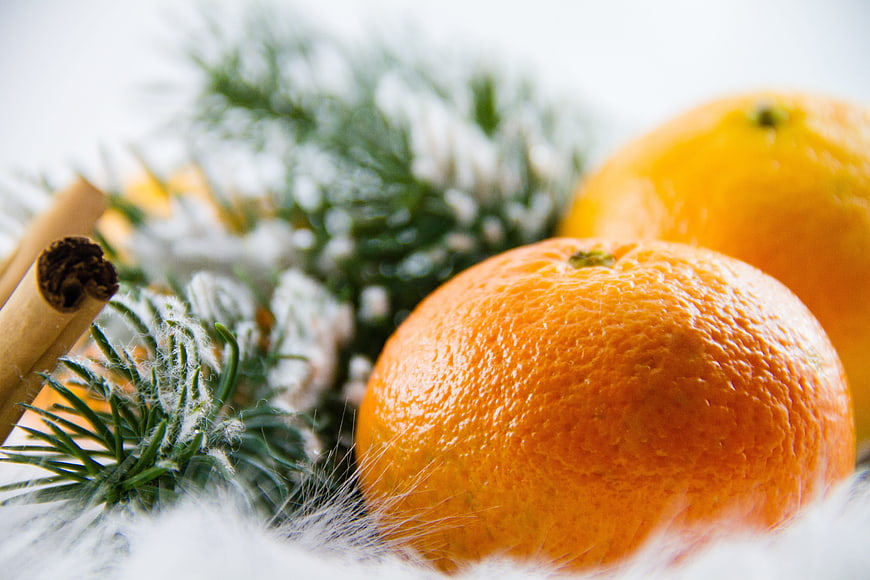 Close-up of fresh tangerines with fir branches and cinnamon sticks