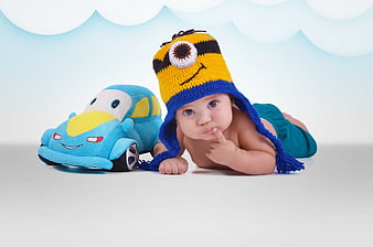 Baby boy in Minion hat with plush car toy