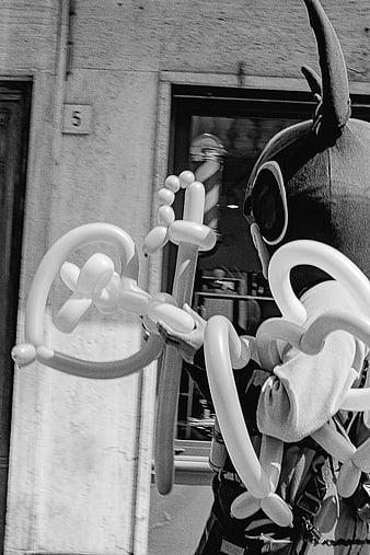 Black and white photo of balloon artist with twisted creations