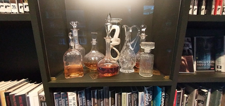 Vintage glass decanters with amber liquid on a bookshelf