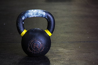 Black Kettlebell with Yellow Accents on Gym Floor