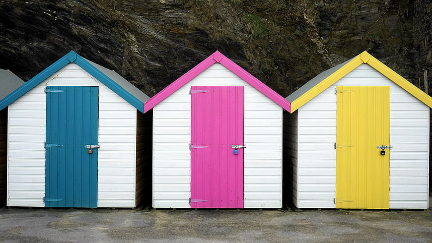 Colorful Beach Huts with Blue, Pink, and Yellow Doors