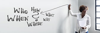 Woman writing question words on whiteboard in office