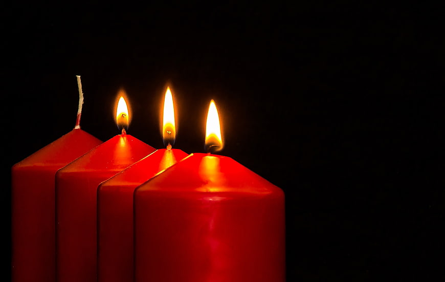 Three Lit Red Advent Candles on Black Background