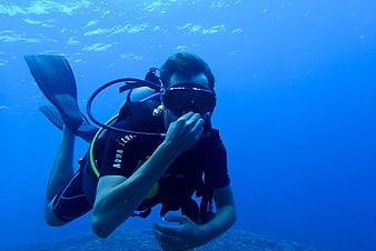 Male Scuba Diver Swimming Underwater in Blue Ocean Water