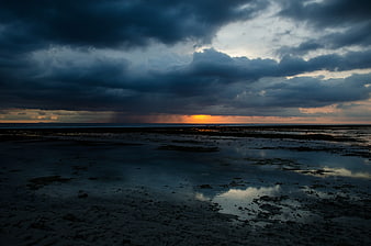 Dramatic Stormy Sunset Over Wet Sandy Beach