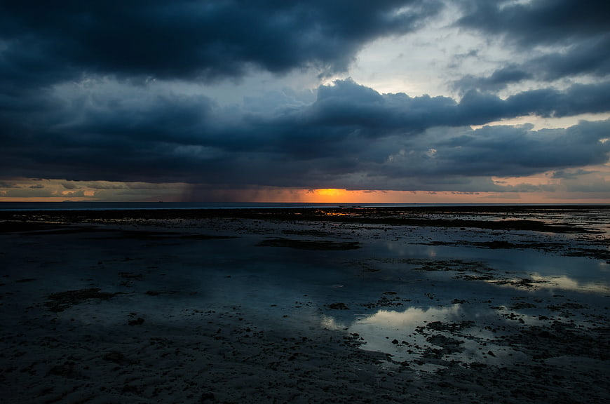 Dramatic Stormy Sunset Over Wet Sandy Beach