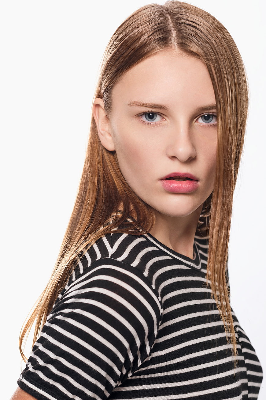 Portrait of young woman with long hair in striped shirt