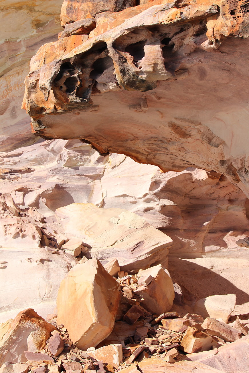 Eroded sandstone rock formation with natural arch in desert landscape