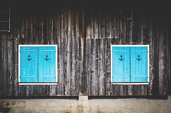 Blue Shutters with Anchors on Weathered Wooden Wall