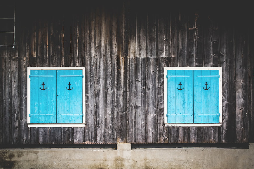 Blue Shutters with Anchors on Weathered Wooden Wall