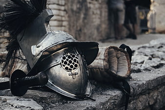 Close-up of silver medieval knight helmet with plume on stone