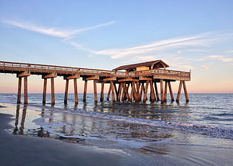 Wooden Fishing Pier on Calm Beach at Sunset