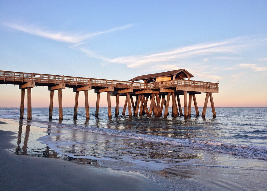 Wooden Fishing Pier on Calm Beach at Sunset