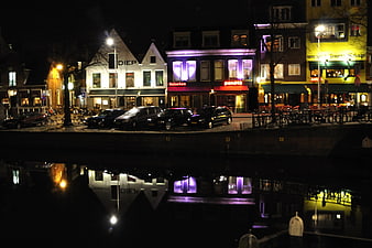 Night view of Groningen canal with illuminated buildings and reflections