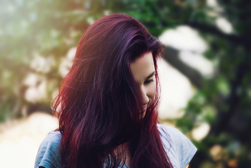 Woman with Red Hair Looking Down in Nature