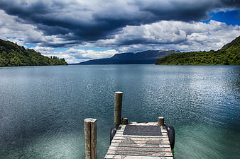 Wooden Dock on Calm Lake with Stormy Sky