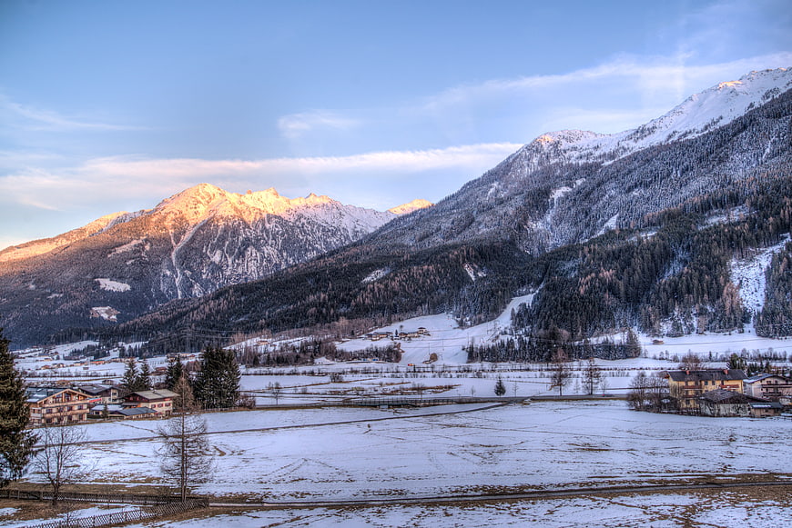 Snowy Alpine Valley with Golden Sunlit Mountain Peaks