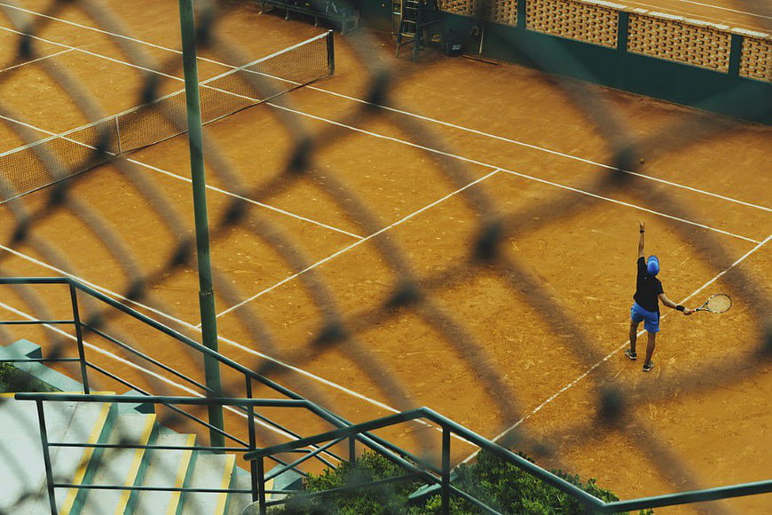 High Angle View of Man Playing Tennis on Clay Court