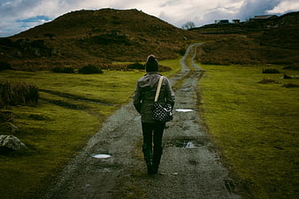 Woman Walking on Gravel Path in Green Countryside