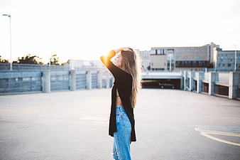 Blonde Woman in Jeans and Black Cardigan on Parking Garage