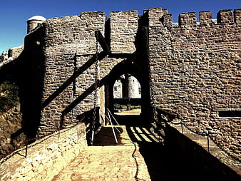 Medieval stone castle gate with drawbridge and chains